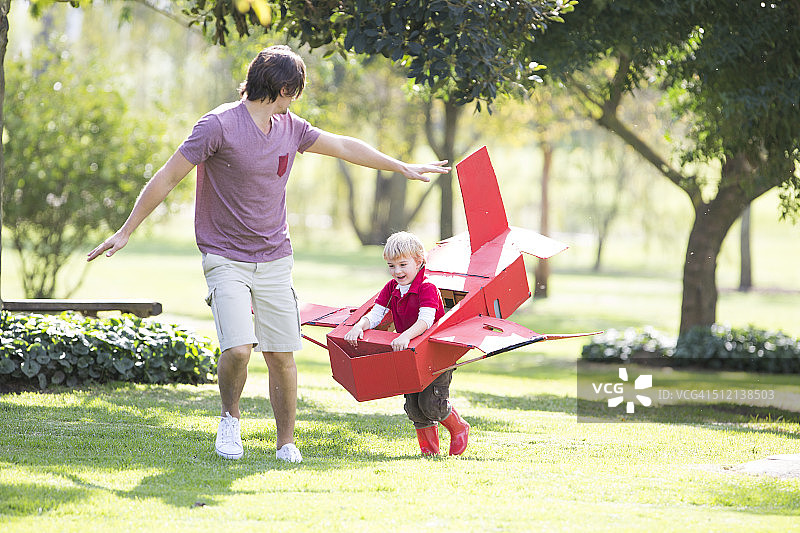 父子俩在公园里玩玩具飞机图片素材