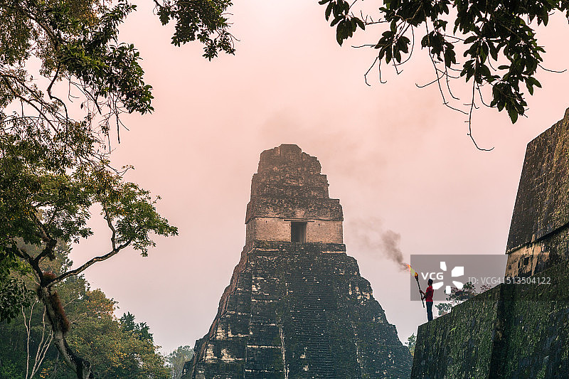危地马拉蒂卡尔的捷豹神庙，一名手持火炬的当地人图片素材