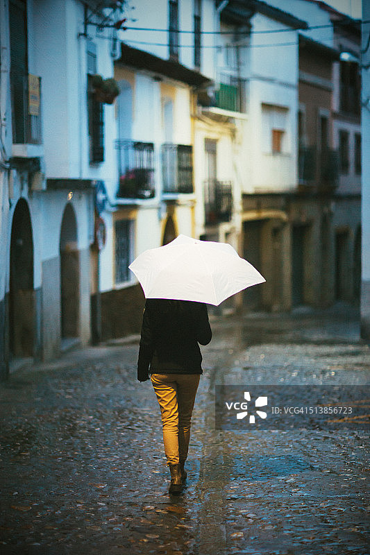 雨中醒来的女人打着白色的伞图片素材