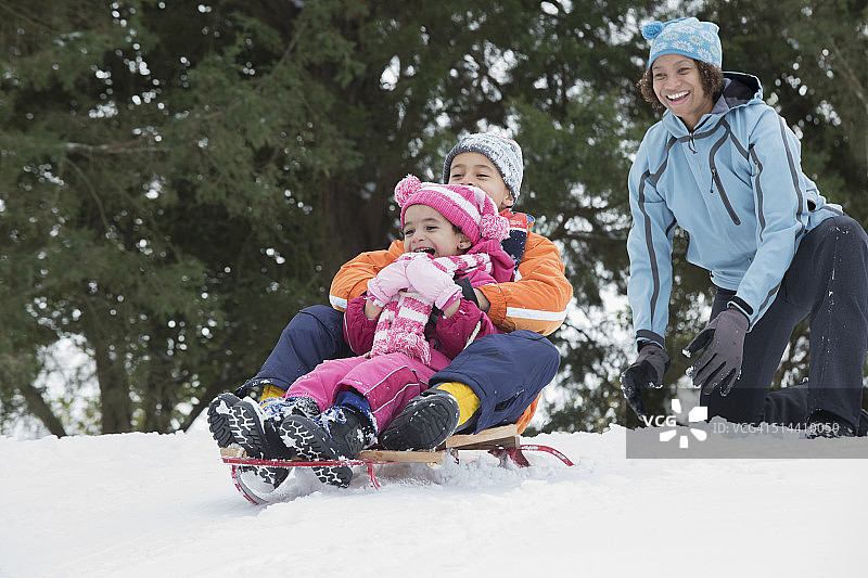 母亲和孩子们在雪山上滑雪图片素材