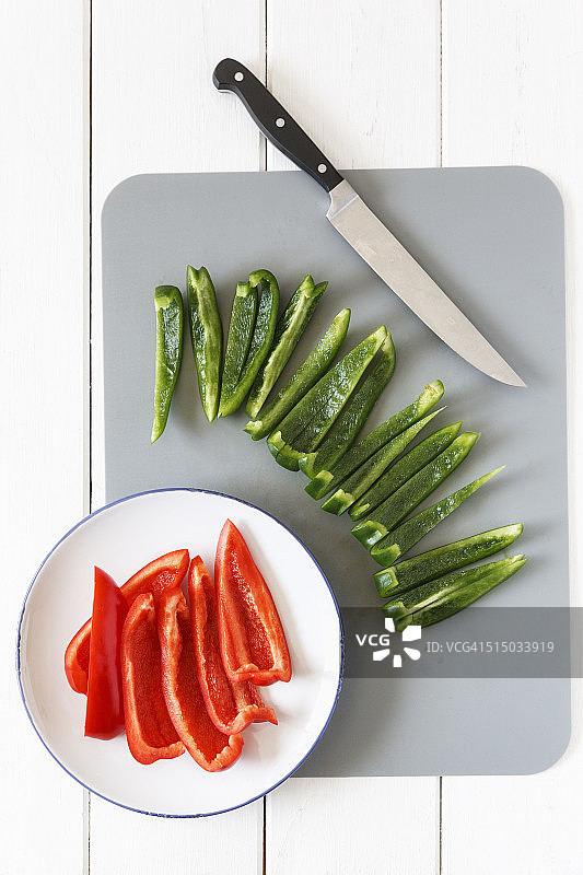 切红绿圆椒，刀和厨房板，俯瞰图片素材