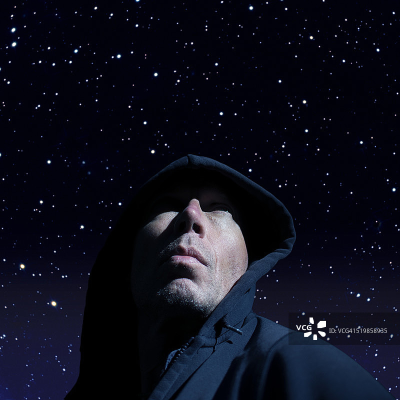 一个戴着头巾的男人的肖像，映衬着星空。图片素材