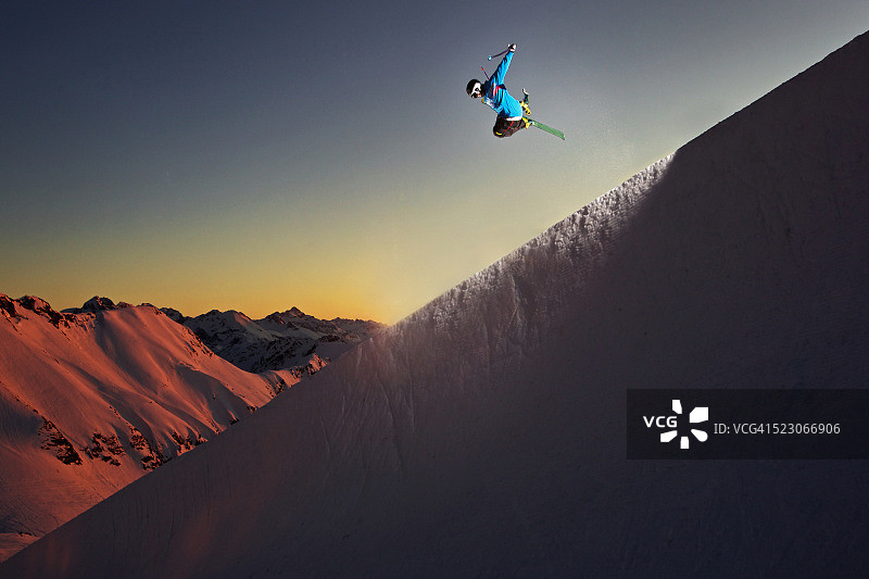 自由式滑雪运动员在山中u型场地跳跃图片素材