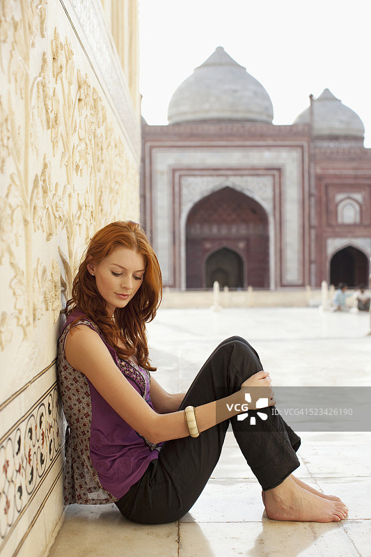 一个女人坐在泰姬陵的走道上图片素材