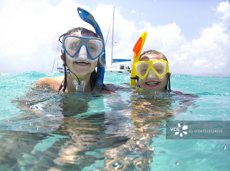 两个女孩(7- 9,10 -12)在海里浮潜图片素材