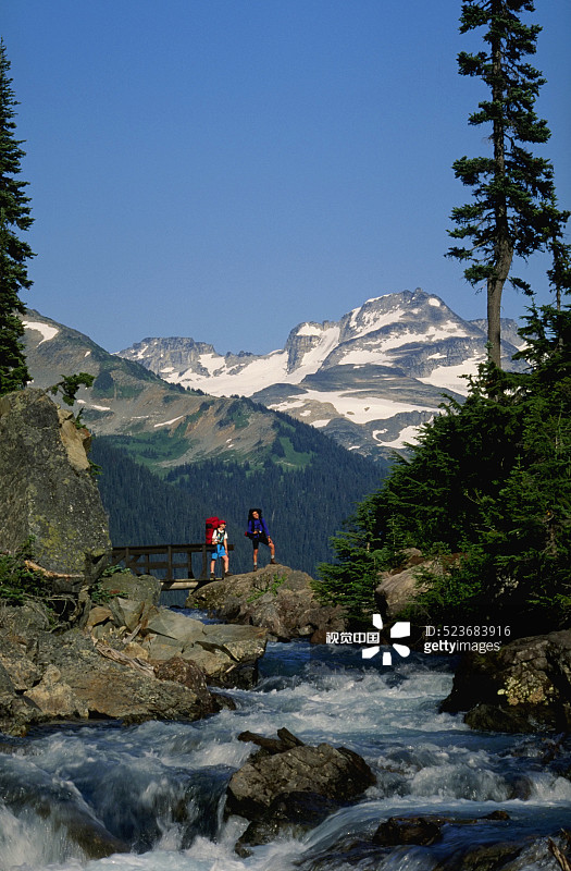 阿尔卑斯山溪流上的背包客图片素材