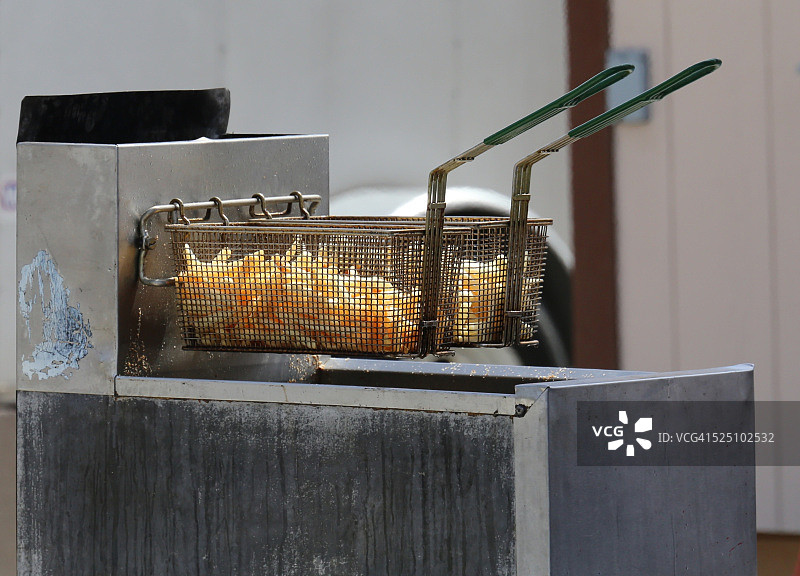一篮子炸薯条被从商业油炸锅中移除图片素材