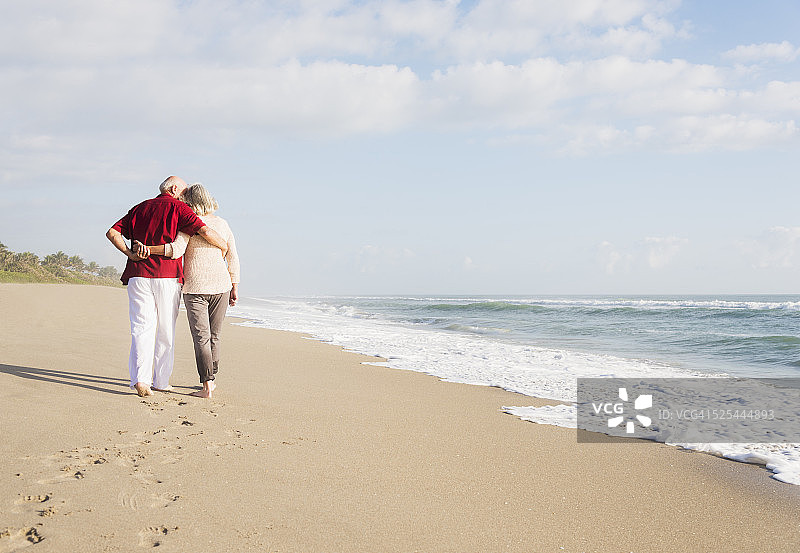 美国，佛罗里达，朱庇特，一对老年夫妇在海滩上散步图片素材