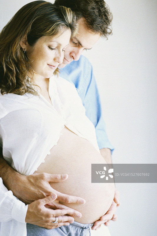 丈夫拥抱怀孕的妻子图片素材