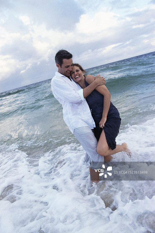 浪花溅在一对大笑的夫妇身上图片素材
