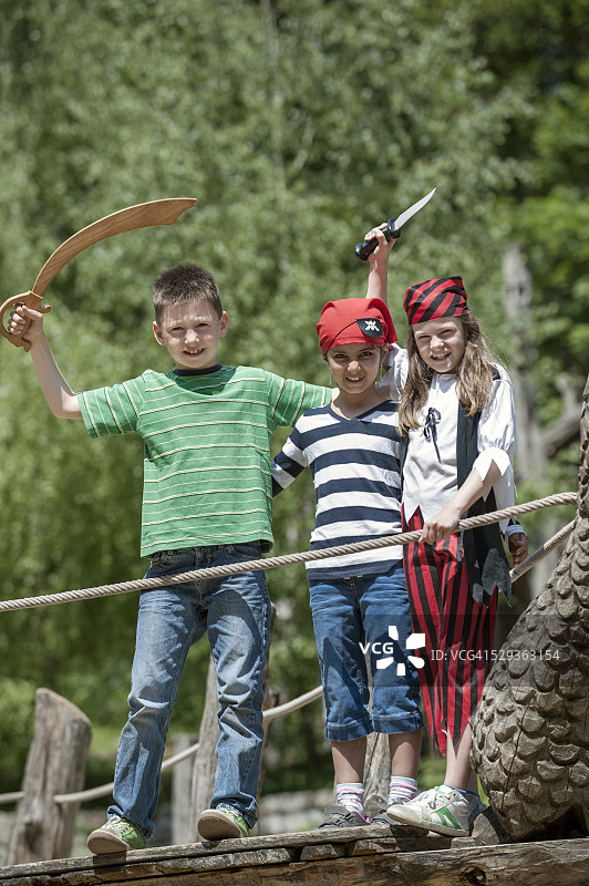 在德国巴伐利亚探险游乐场，三个朋友装扮成海盗在海盗船上玩耍图片素材