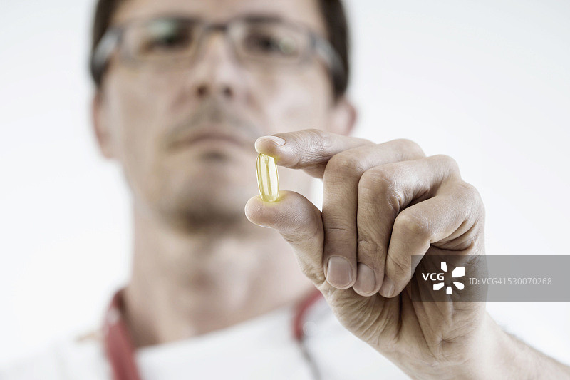 德国巴伐利亚，男医生展示一种膳食补充剂胶囊图片素材