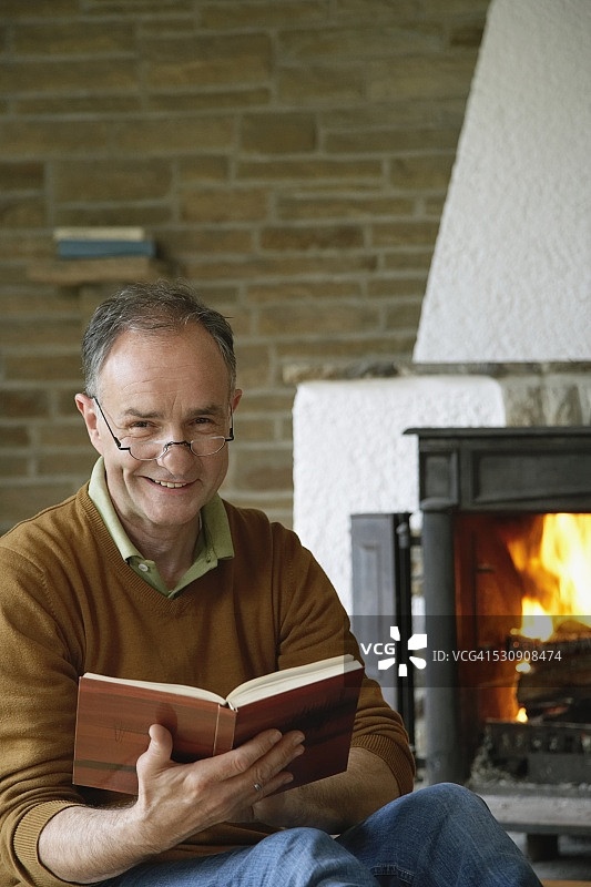 壁炉旁阅读的男人图片素材