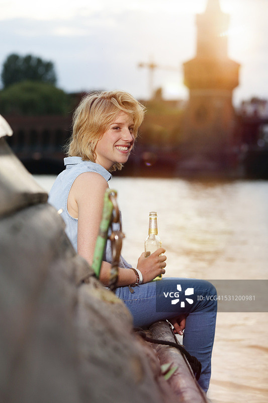 德国，柏林，年轻女子在施普雷河欣赏日落图片素材