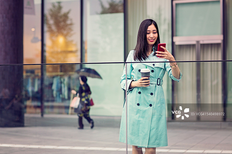 一个年轻的日本女人正在看她的手机图片素材