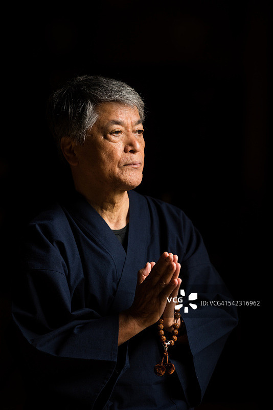 一名日本老人在寺庙里祈祷图片素材