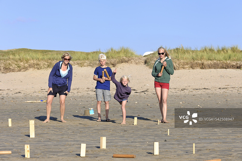 妈妈和三个孩子在海滩上玩库布图片素材