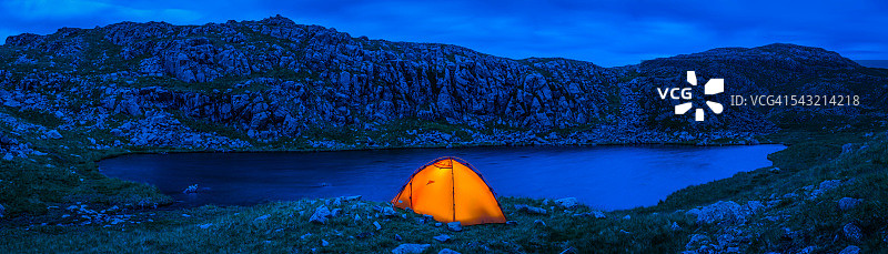 橘黄色圆顶帐篷露营在遥远的山野湖畔全景图片素材
