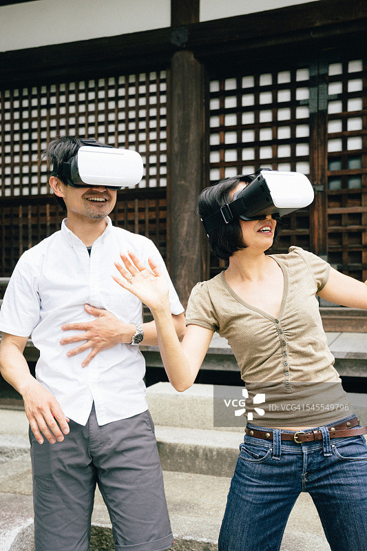 夫妇使用虚拟现实模拟器户外图片素材