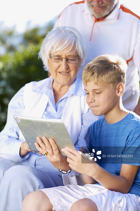 孙子和祖父母在使用数字平板电脑图片素材