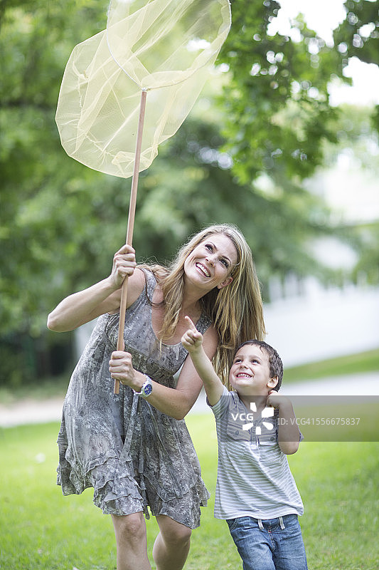 母亲和儿子用网捉蝴蝶图片素材