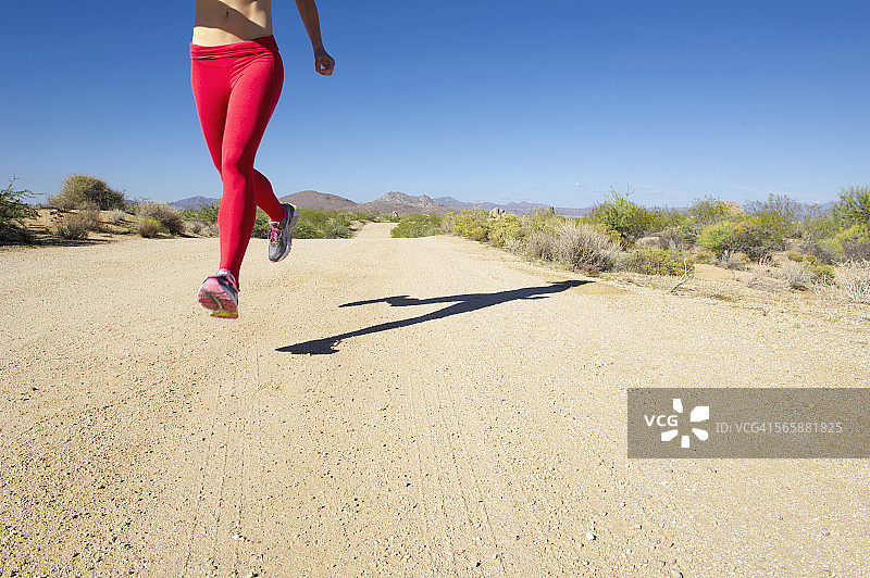 一个白人女人在偏僻的土路上跑步图片素材