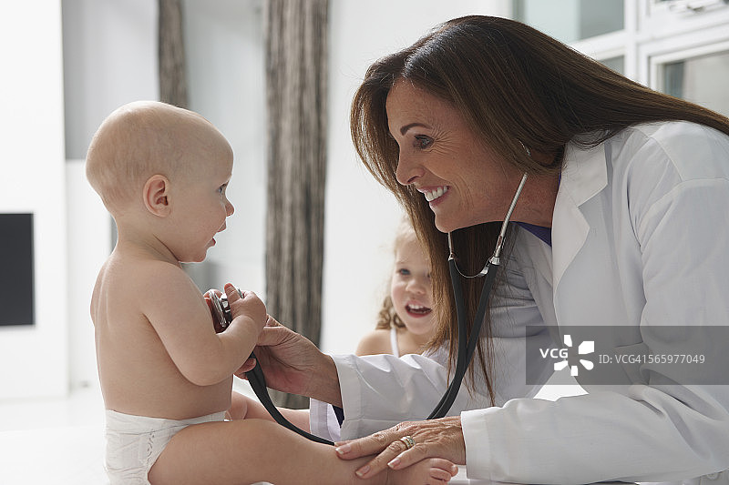 一个白人医生在听婴儿的心跳图片素材