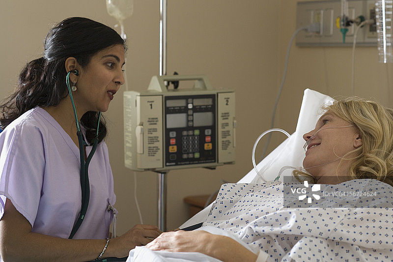 一名女护士检查一名女性病人的血压图片素材