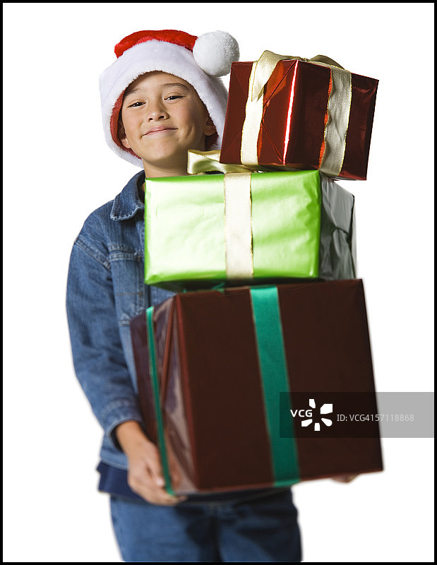 一个男孩拿着一堆圣诞礼物的肖像图片素材