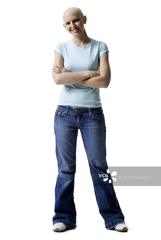 一个年轻的秃头女人的肖像，站在她的双臂交叉图片素材