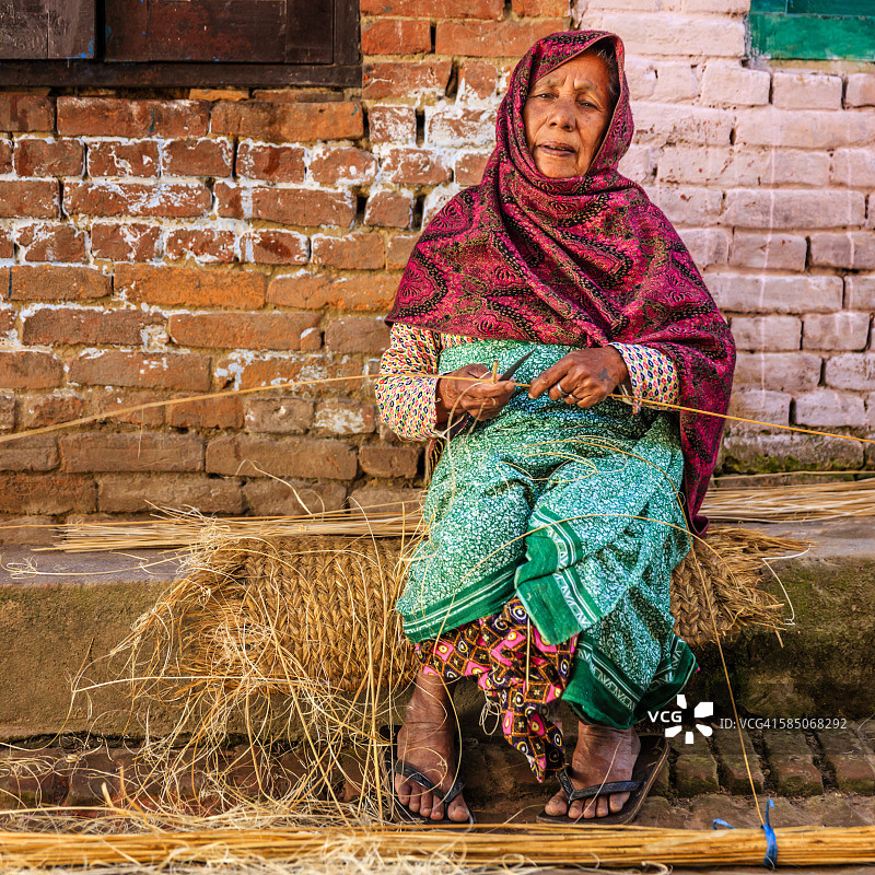在尼泊尔巴德岗，一名尼泊尔妇女正在用手工制作扫帚图片素材