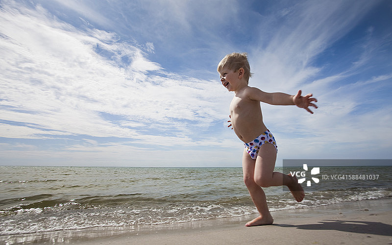 男孩在沙滩上奔跑图片素材