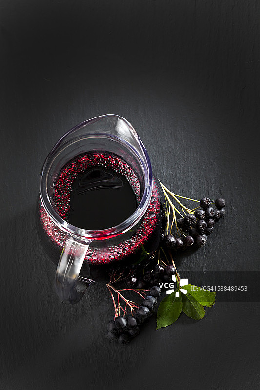 瓶子里的Aronia果汁，石板上的颈莓图片素材