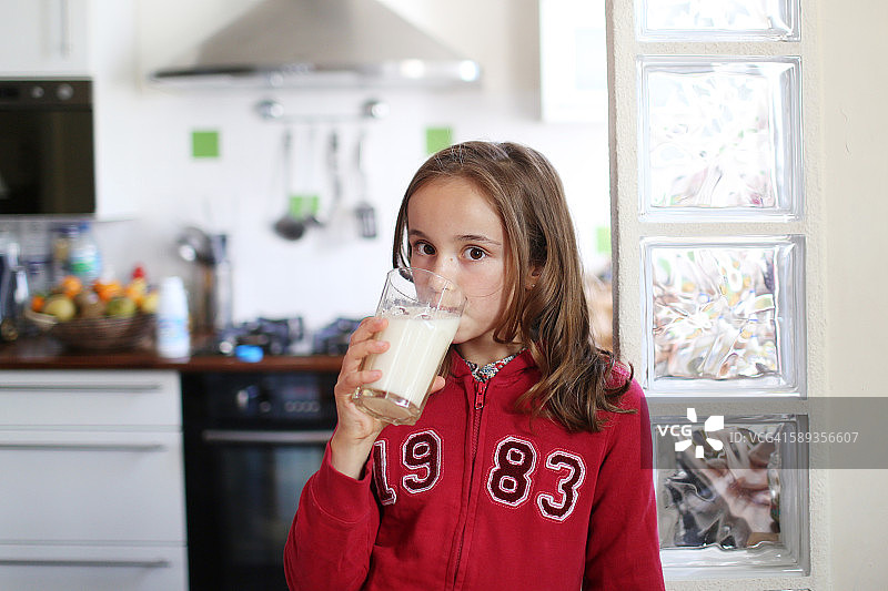 一个10岁的女孩在喝一杯牛奶图片素材