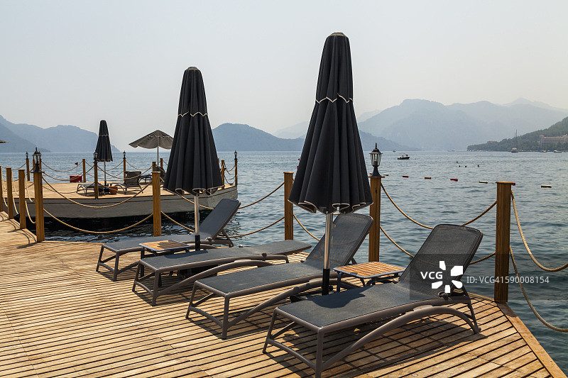 码头上有桌椅和阳伞，海面平静图片素材