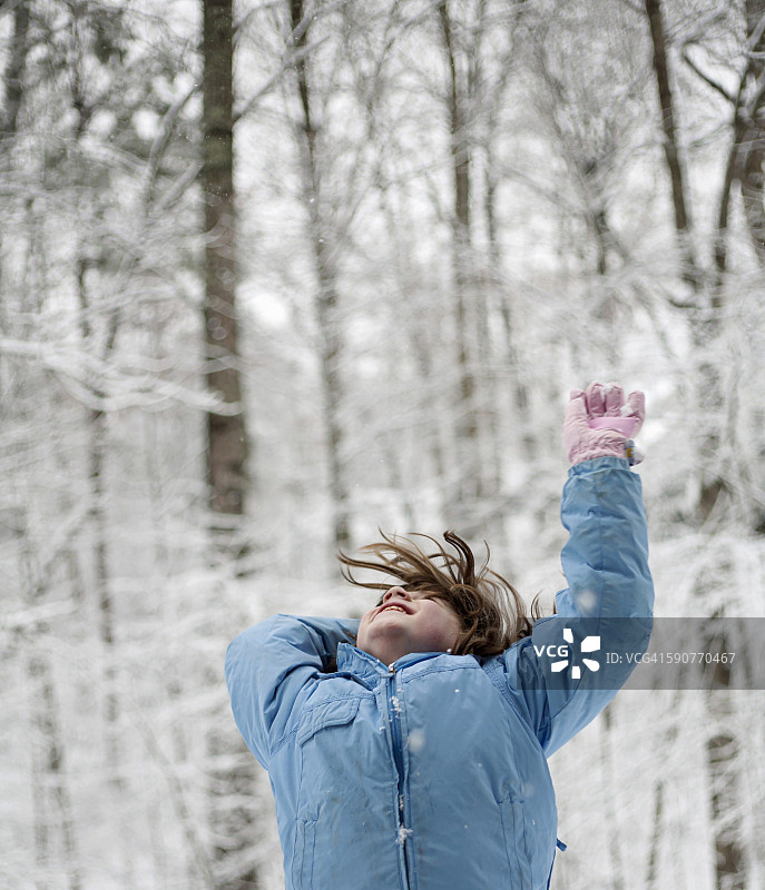 女孩在树林里扔雪图片素材