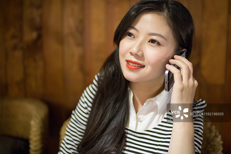 年轻的亚洲女子接听手机图片素材