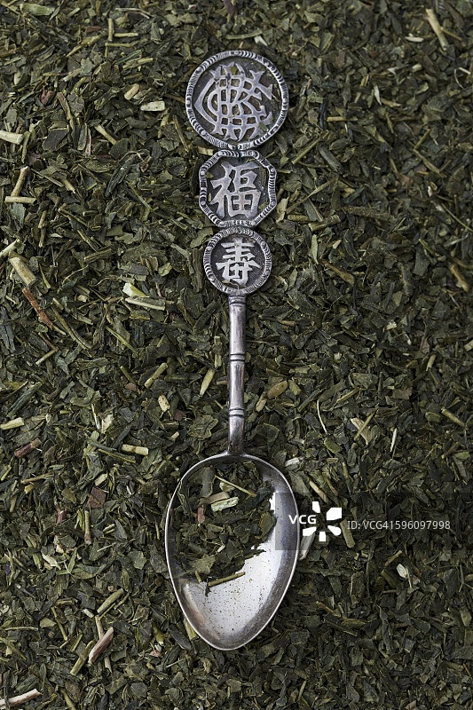 一个东方银勺躺在煎茶的叶子上图片素材