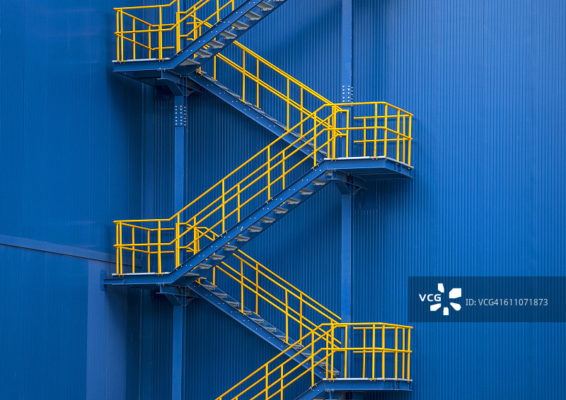黄色的金属楼梯对着蓝色的墙图片素材