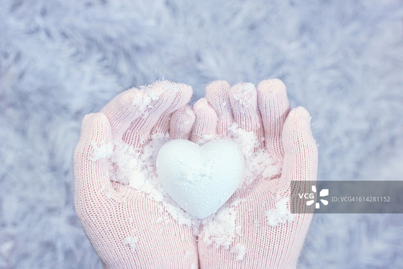 冬天爱心形的雪在手上戴着手套图片素材