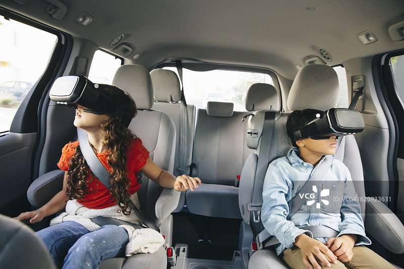 混合种族儿童使用虚拟现实眼镜在汽车图片素材