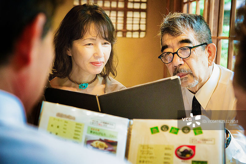年长日本朋友在京都小餐馆看菜单图片素材