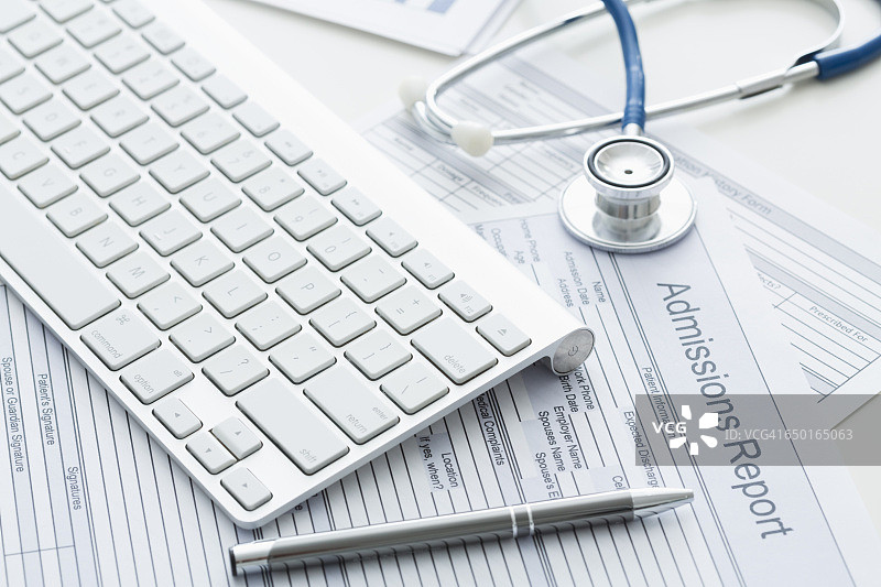 医疗文件上的键盘、笔和听诊器图片素材