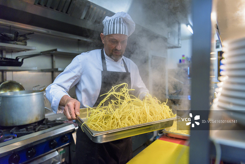 厨师在传统的意大利餐厅厨房准备新鲜的意大利面图片素材