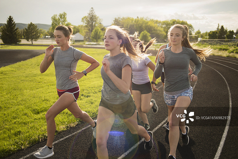 年轻女子运动员在跑道上转弯图片素材