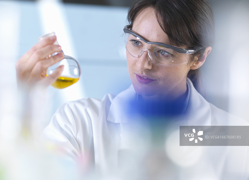 科学家在实验室实验中观察烧杯中的化学公式图片素材