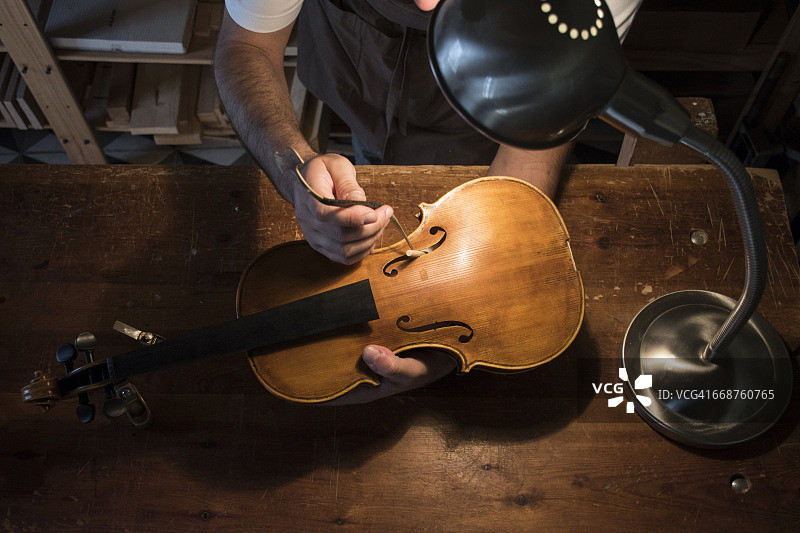 卢瑟尔在他的工作室调整小提琴的音柱图片素材