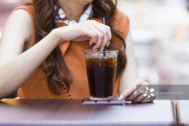 商业女性坐在露天咖啡馆和冰咖啡图片素材