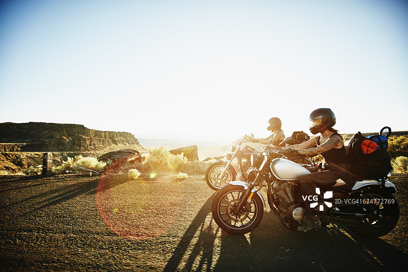夏天的傍晚，摩托车手在公路上骑摩托车图片素材