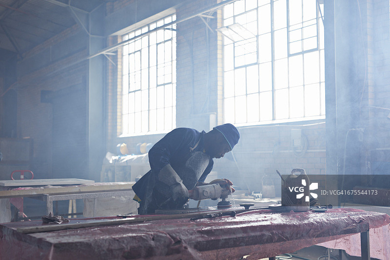 一名男子在工厂打磨大理石图片素材